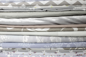 lots of bundles of different verities of new fabric in many color collections kept on the shelf of a local store in Asia