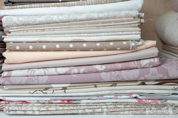 lots of bundles of different verities of new fabric in many color collections kept on the shelf of a local store in Asia