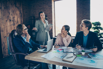 Four nice chic elegant stylish trendy attractive cheerful business sharks experts listening to presenter financial report at modern industrial loft interior work place station