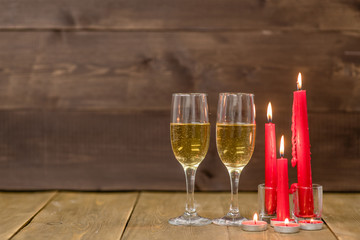 Pair glass of champagne with candles. Wooden background with empty space for text