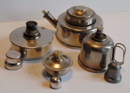 R&eacute;chauds &agrave; alcool, objets anciens pos&eacute;s sur fond blanc