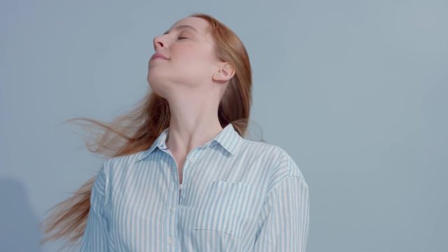 gingerhead red hair, ginger hair model with blue big eyes in studio with blowing hair in slow motion from 60fps. Beauty straight shiny hair blowing,