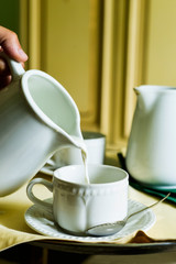 serving milk in a white ceramic cup