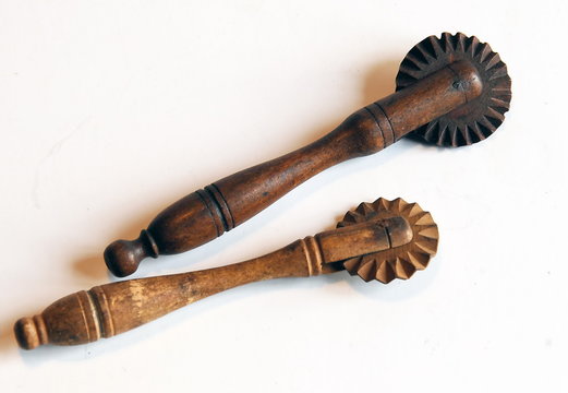 Roulettes en bois pour d&eacute;coupe de la p&acirc;te &agrave; tarte, objet ancien pos&eacute; sur un fond blanc