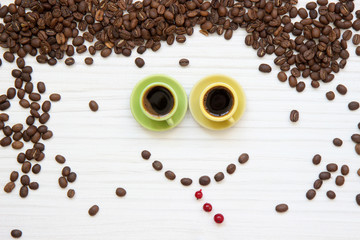 coffee beans and cup of coffee on white background.  funny face made of coffee beans.