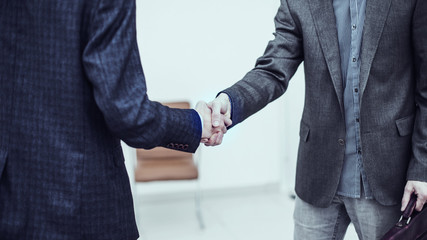 handshake between client and Manager on the background of the office