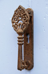 Heurtoir ancien en métal fixé sur une porte bleue en bois