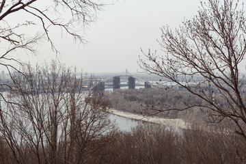 View of a gray autumn city with a river.