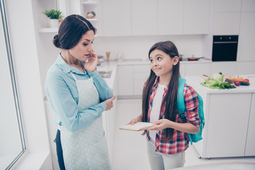 Portrait of two nice-looking cute lovely attractive cheerful cheery people girl showing good marks to mature mommy deciding in light white kitchen interior indoors