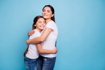 Close up photo adorable amazing pretty two people brown haired mum small little daughter stand close eyes closed holding hands arms circle wearing white t-shirts isolated on bright blue background