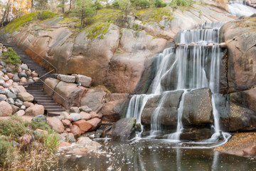 Fototapeta na wymiar Waterfall cascading over rocks in Sapokka landscaping park Kotka, Finland