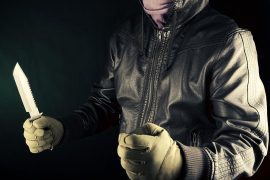 Dangerous criminal hold knife in hand.Large sharp weapon ready for robbery or to commit a homicide.Assassin man.
