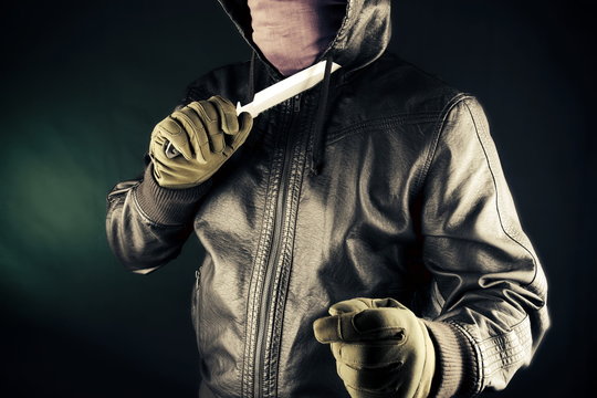 Dangerous criminal hold knife in hand.Large sharp weapon ready for robbery or to commit a homicide.Assassin man.
