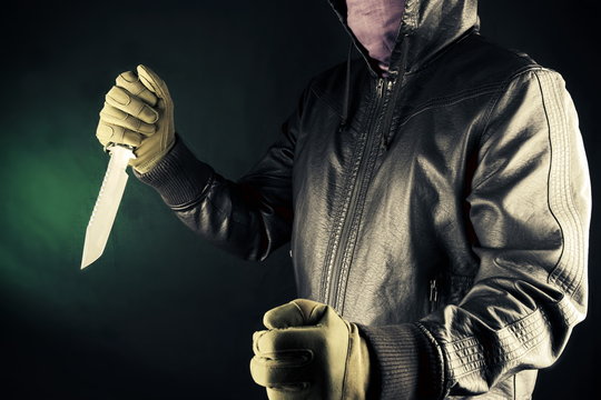 Dangerous criminal hold knife in hand.Large sharp weapon ready for robbery or to commit a homicide.Assassin man.