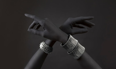Black woman's hands with many different Silver jewelry. Oriental Bracelets on a black hand.