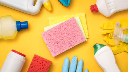 Home cleaning products. Must have concept. Supplies assortment on yellow background. Flat lay.
