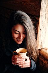 woman with a mug of tea look in mug and smile