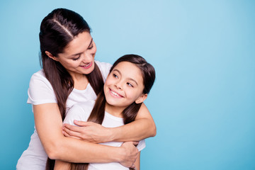 Close up photo pretty two people brown haired mum small little daughter missed glad see each other stand hugging piggy back nice rejoice wearing white t-shirts isolated on bright blue background - obrazy, fototapety, plakaty