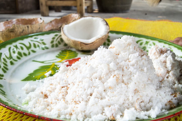 White coconut shells are scraped into the tray.