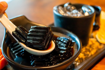grass jelly of a type of thai dessert on white spoon with Sweets,caramel  as yummy traditional...