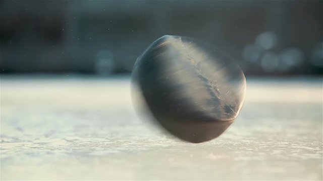 Quick spin of black hockey puck on ice rink HD 1020x1080
