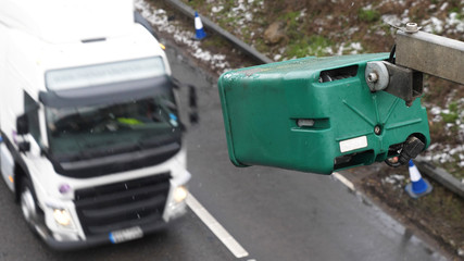 winter day view average speed traffic camera under falling snow over UK Motorway