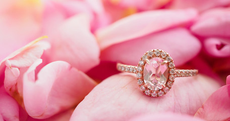 Jewelry pink diamond ring on beautiful rose petal background close up