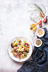 Salad with figs Mozzarella Thymean, Cedar Nut and honey.Healthy Food on the Stone Background. Nutrition Concept.Top View.Copy space for Text.