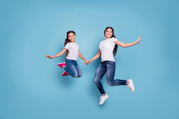 Fototapeta na wymiar Full length body size view of two nice cute lovely attractive cheerful funny slim sporty people in white t-shirt holding hands having fun rejoicing isolated over blue pastel background