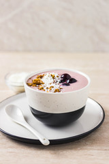 Healthy breakfast, cherry smoothie with granola, honey and coconut flakes. Selective focus, space for text.