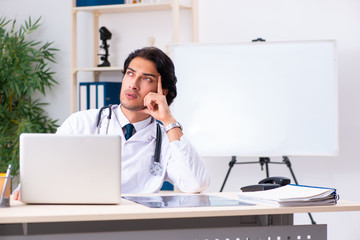 Young handsome doctor working in clinic