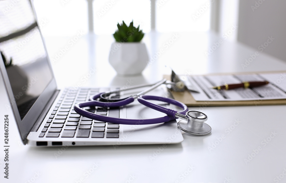 Wall mural stethoscope lying on a laptop keyboard in a concept of online m