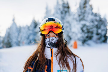 Ski, skier, sun and winter fun - woman enjoying ski vacation. Sport, leisure and people concept - happy young woman in ski goggles outdoors. Ski resort - Image