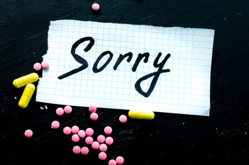 On a black background pills closeup. Suicide note. Suicide