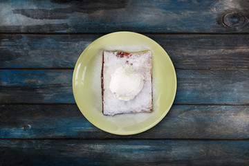 Strudel with cherry, served on the ceramic plate with the ice cream.