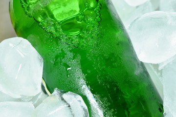 green beer bottle on ice in plastic tray