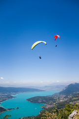 Paragliders Flying over Annecy Lake and Mountain Landscape in Blue Sky