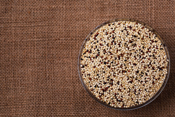 Quinoa seeds in glass bowl from above.