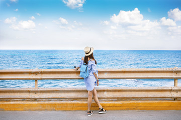 Girl looking into the distance, against the blue sea, summer mood, woman in hat, sunlight