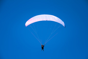 Paraglider Instructor Flying with Customer in Blue Summer Sky