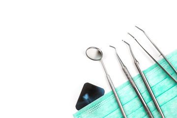 Dentist tools on mask and x-ray photo.