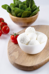 Fresh cherry tomatoes and mozzarella on white background