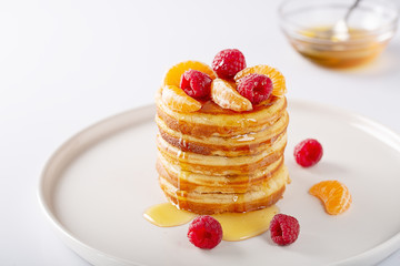 Fresh homemade pancakes with raspberry fruits and honey