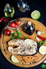 red fish salmon baked with spices and lemon on a wooden board