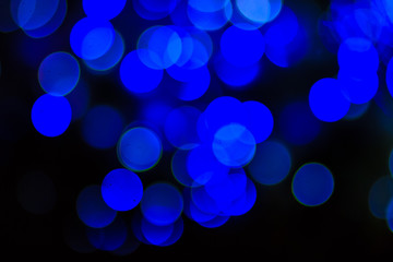 Beautiful blue bokeh abstract light background. Wonderful Defocused abstract blue christmas background. Abstract christmas lights as background in the night with noise grain and poor light.