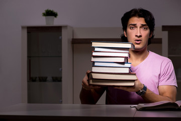 Male handsome student preparing for exams late at home