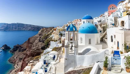 Poster Blick auf die weißen Häuser und die blauen Kuppeln der Kirchen in Oia auf Santorini, Kykladen, Griechenland © moofushi