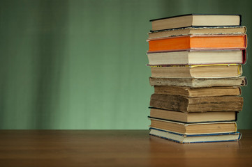 Stack of books on a wooden background. Vintage old books on brown wooden deck tabletop