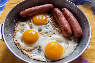 Three sausages and fried eggs.