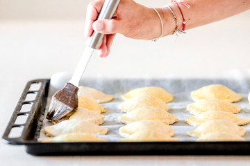 Preparar las empanadas con la mano pintando de huevo antes de hornear